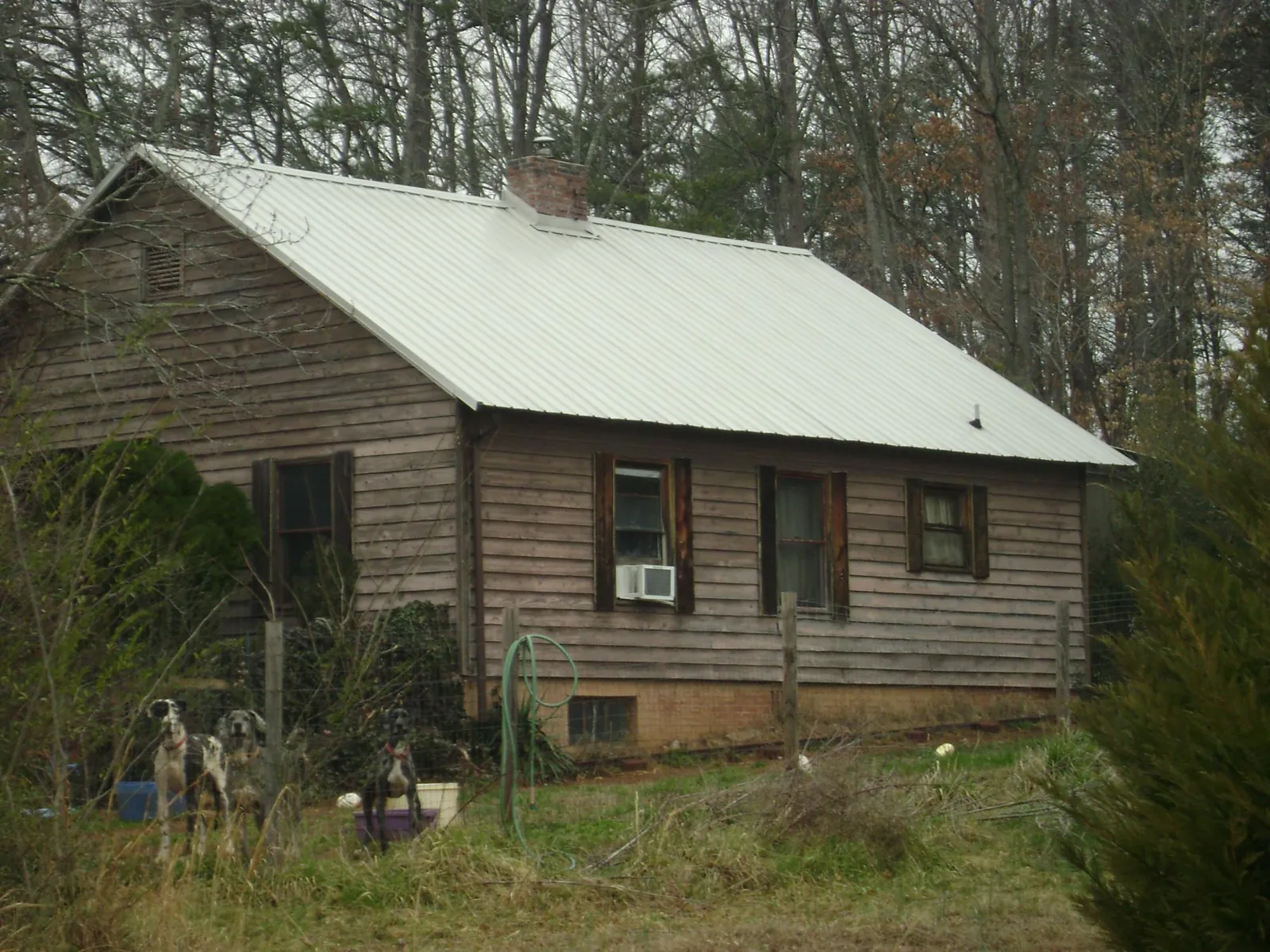 White metal roof on an old wood sided farmhouse, from a Metal Roof Installation job in Middle Amana